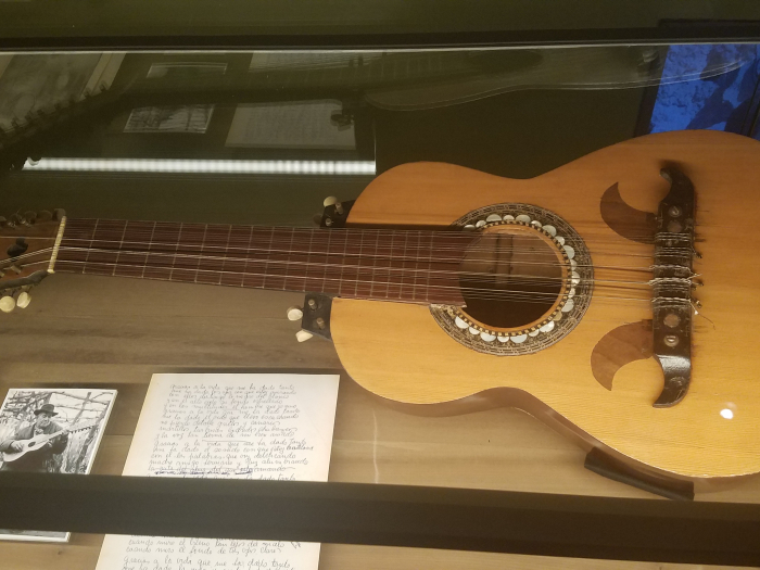 guitar and lyrics in glass case